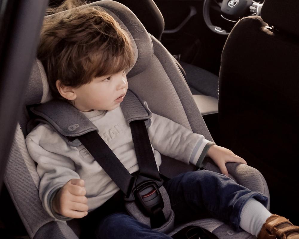 Chłopiec siedzący zapięty w foteliku samochodowym I-GUARD zamontowanym w samochodzie