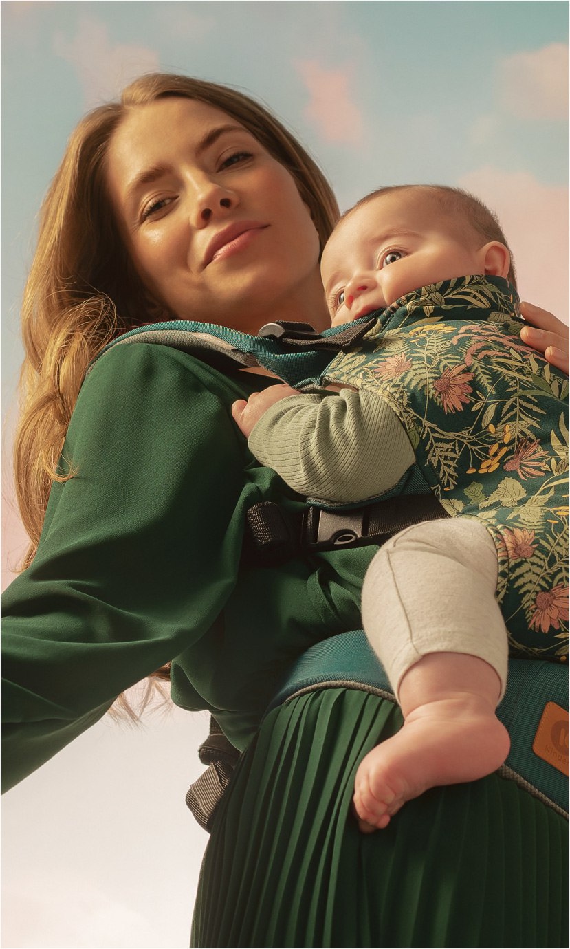 Frau mit Baby in Tragetasche
