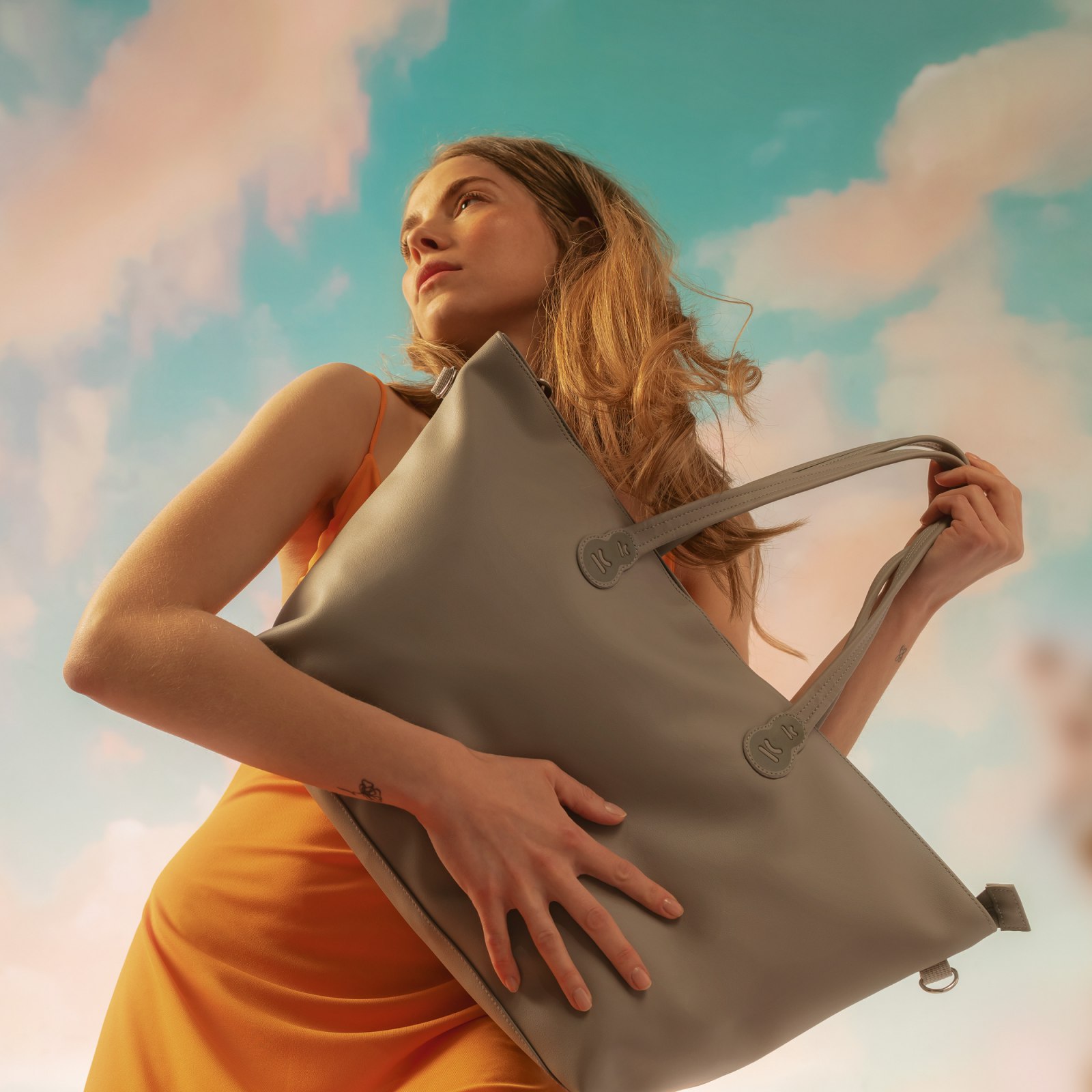 Kobieta na tle chmur z torbą z ekskluzywnej kolekcji Nature Vibes