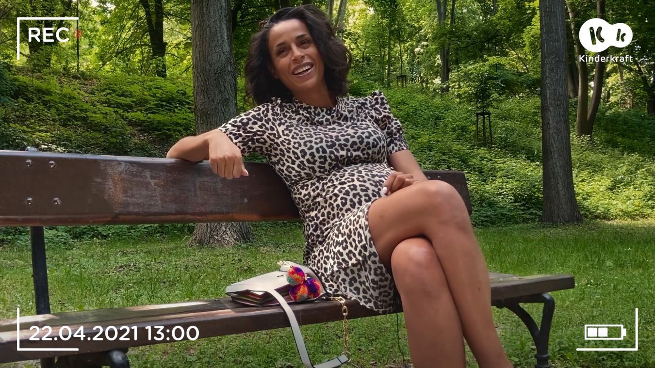 Aktorka Ola Szwed siedzi na ławce w parku - scena z serialu Kinderkraft