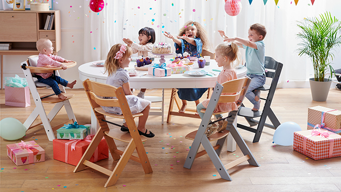 W domu podczas urodzin grupa dzieci siedzi na krzesełkach ENOCK przy stole.