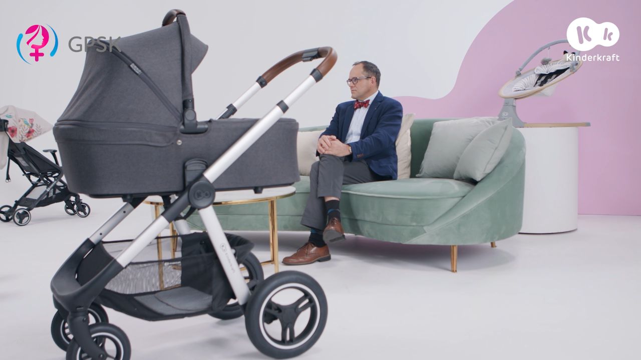 Prof. dr hab. Jan Mazela – pediatra, neonatolog siedzi na kanapie, na pierwszym planie widać wózek Everyday Kinderkraft.